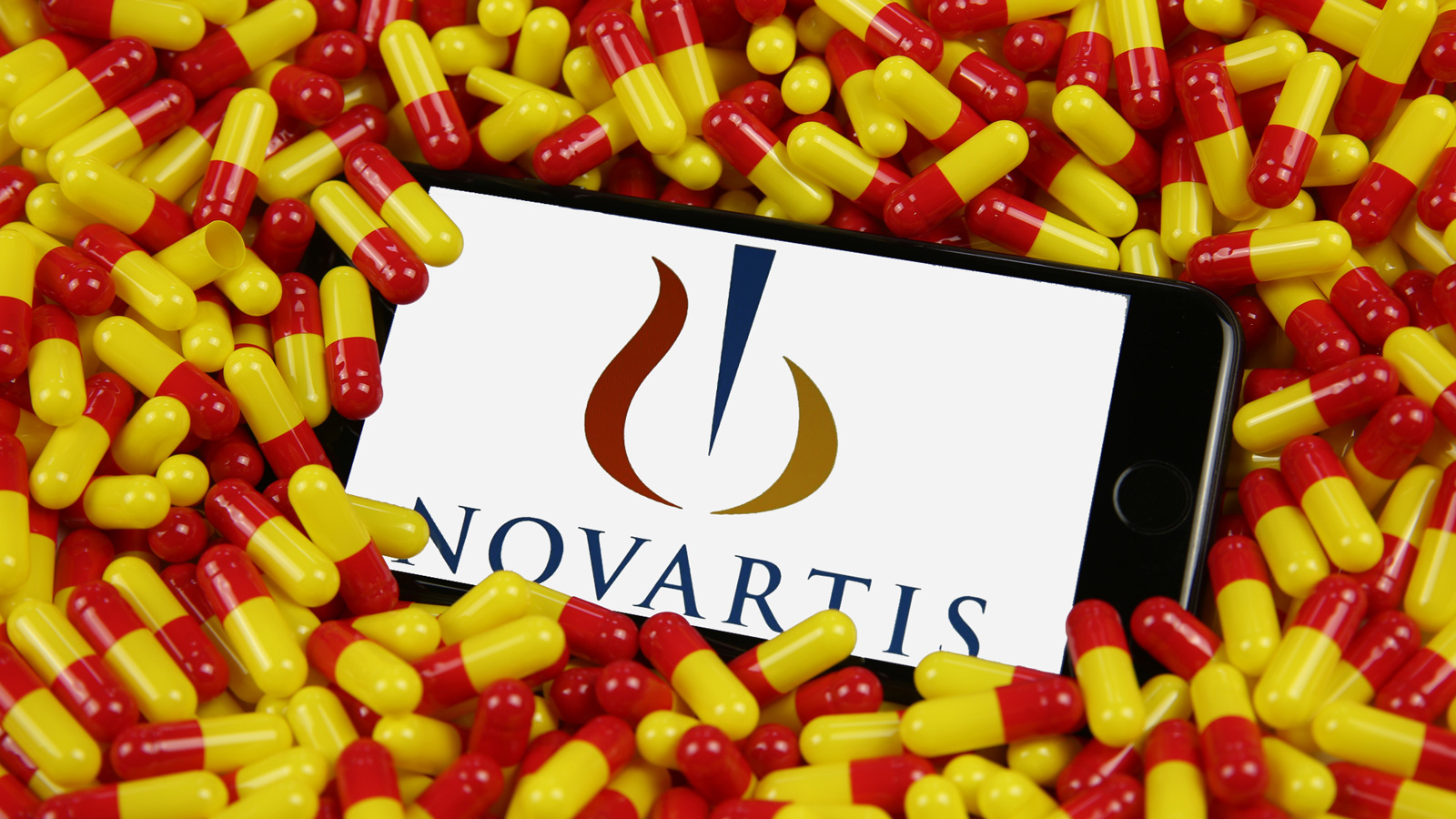 Novartis logon on a phone in a bed of pills