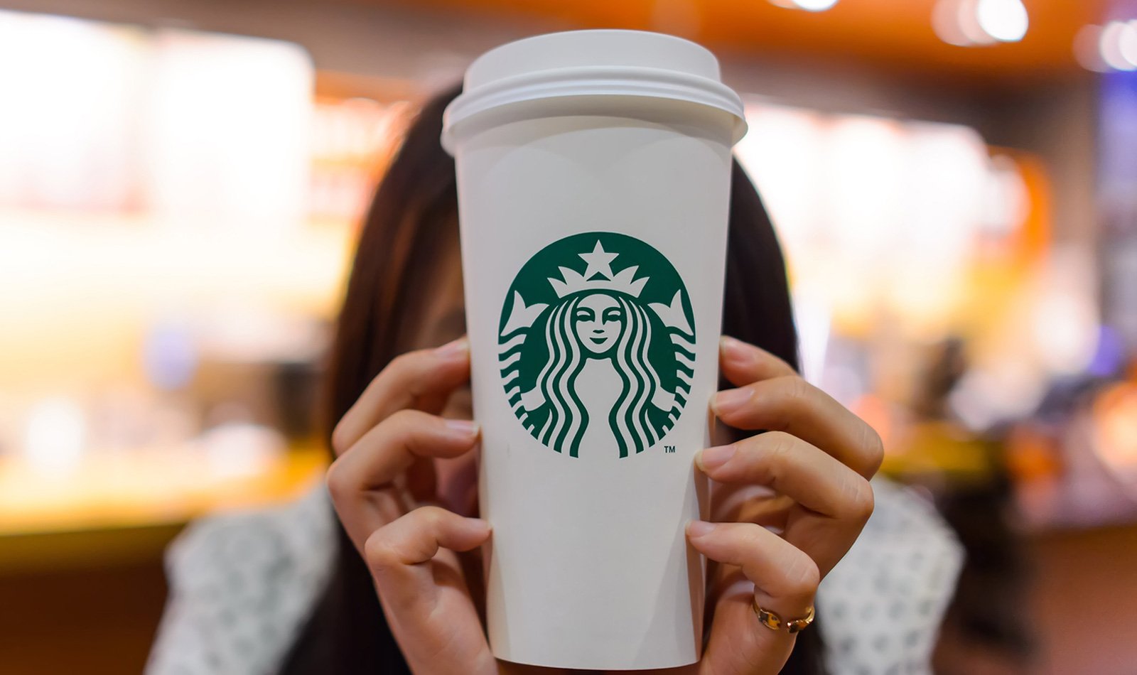 Woman holding a Starbucks coffee