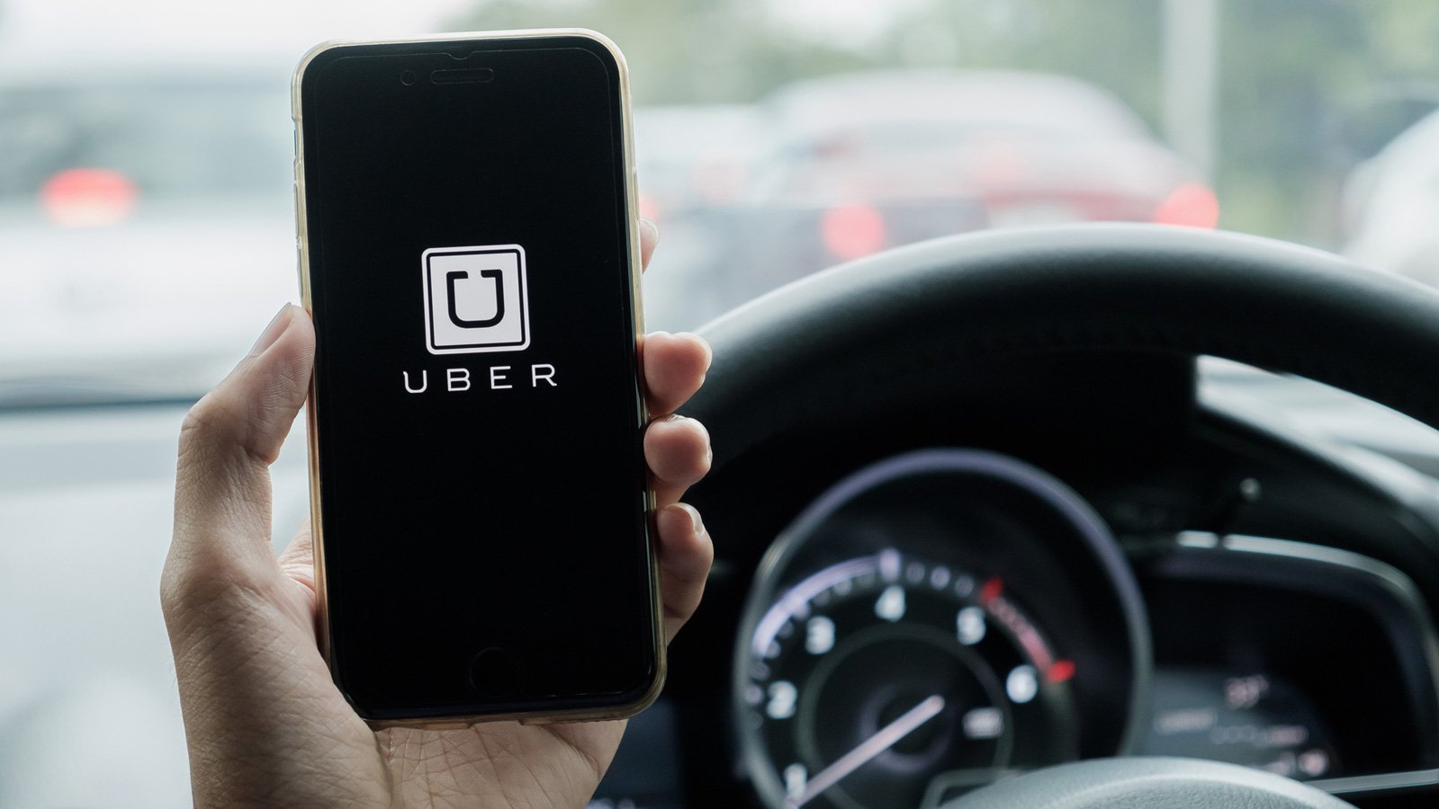 Holding up a phone with Uber logo on it