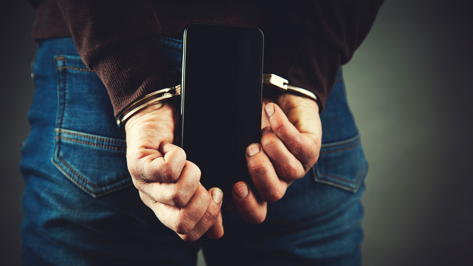 Arrested person holding a phone