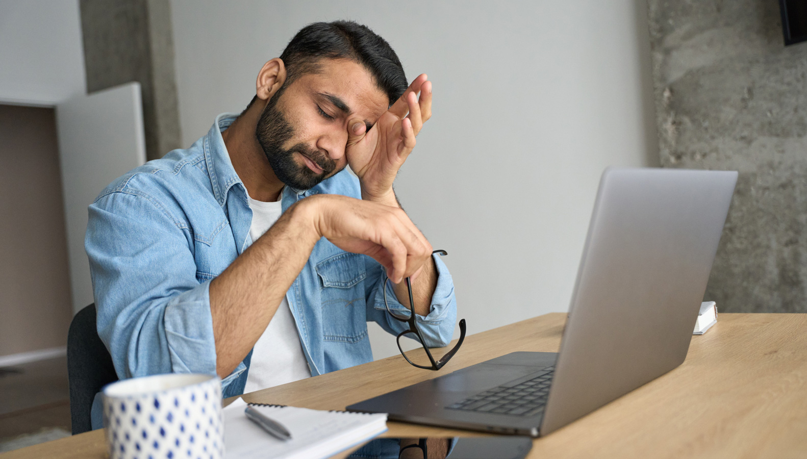 Person rubbing their eye in fatigue