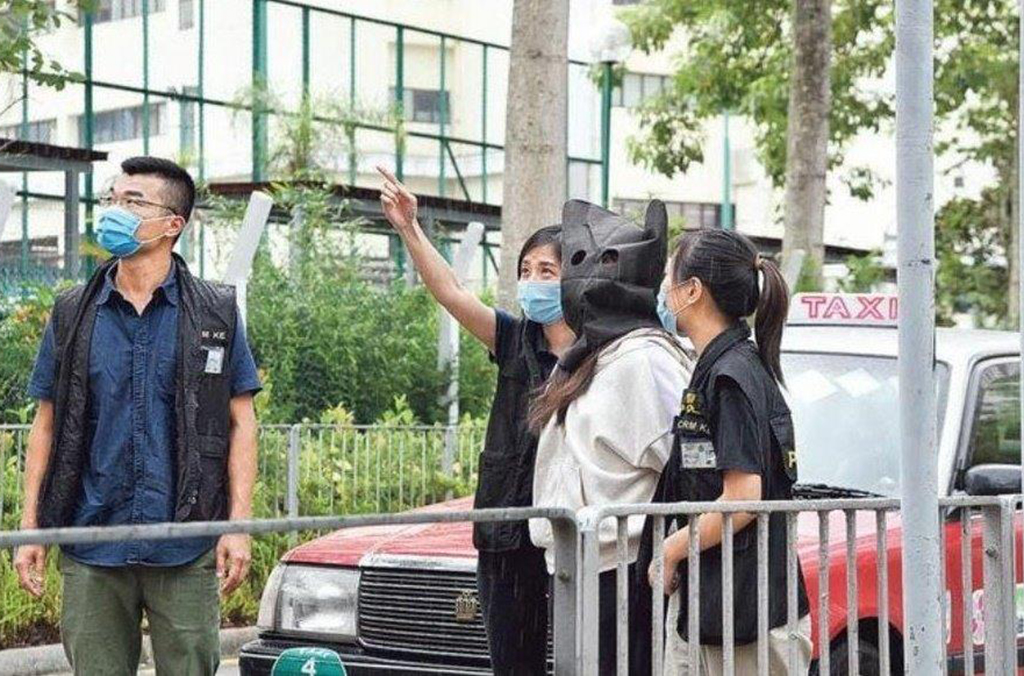 Hong-Kong police arresting a scammer following a raid in telephone center