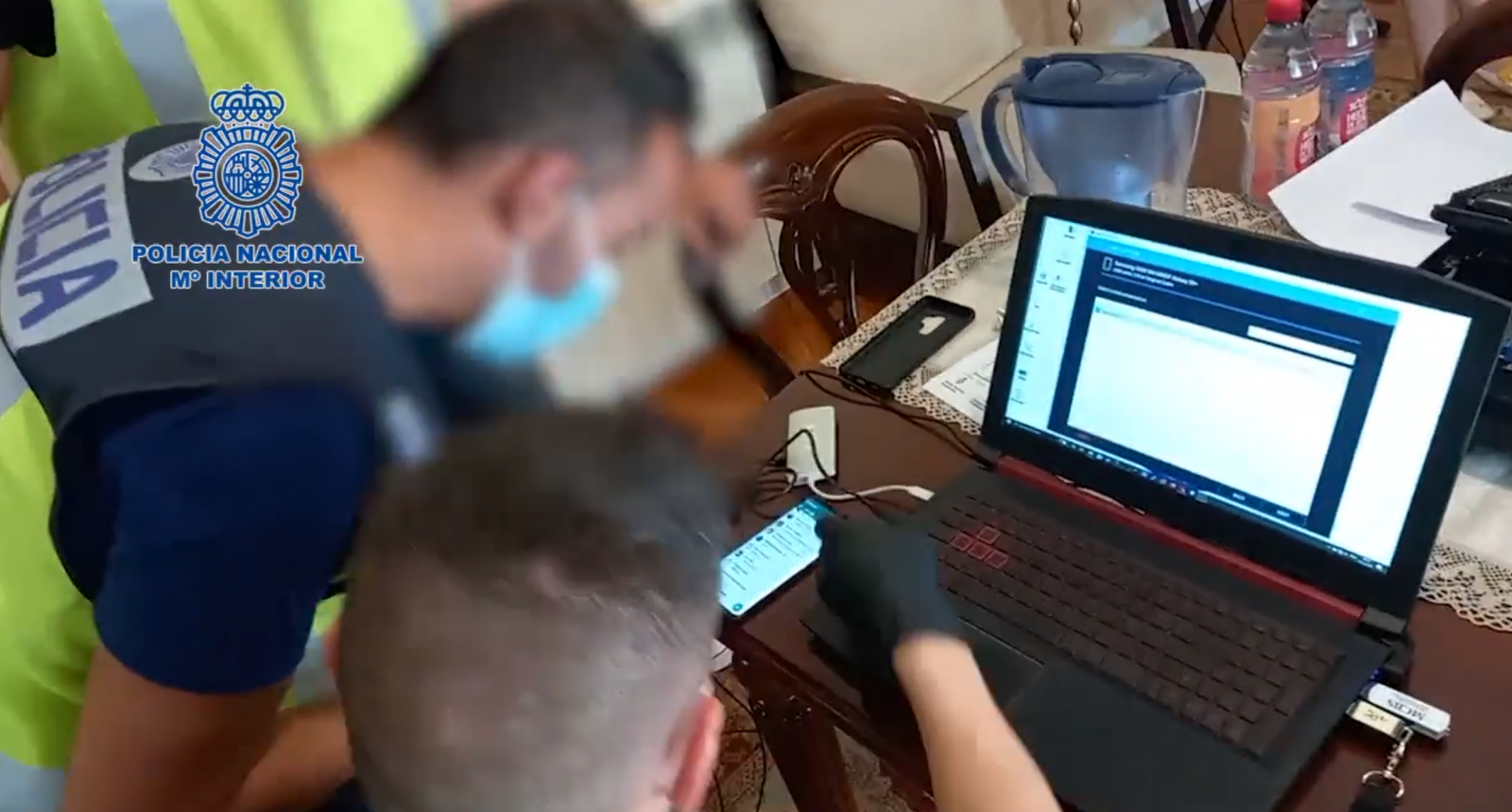 Policías españoles recogiendo pruebas de dispositivos confiscados 